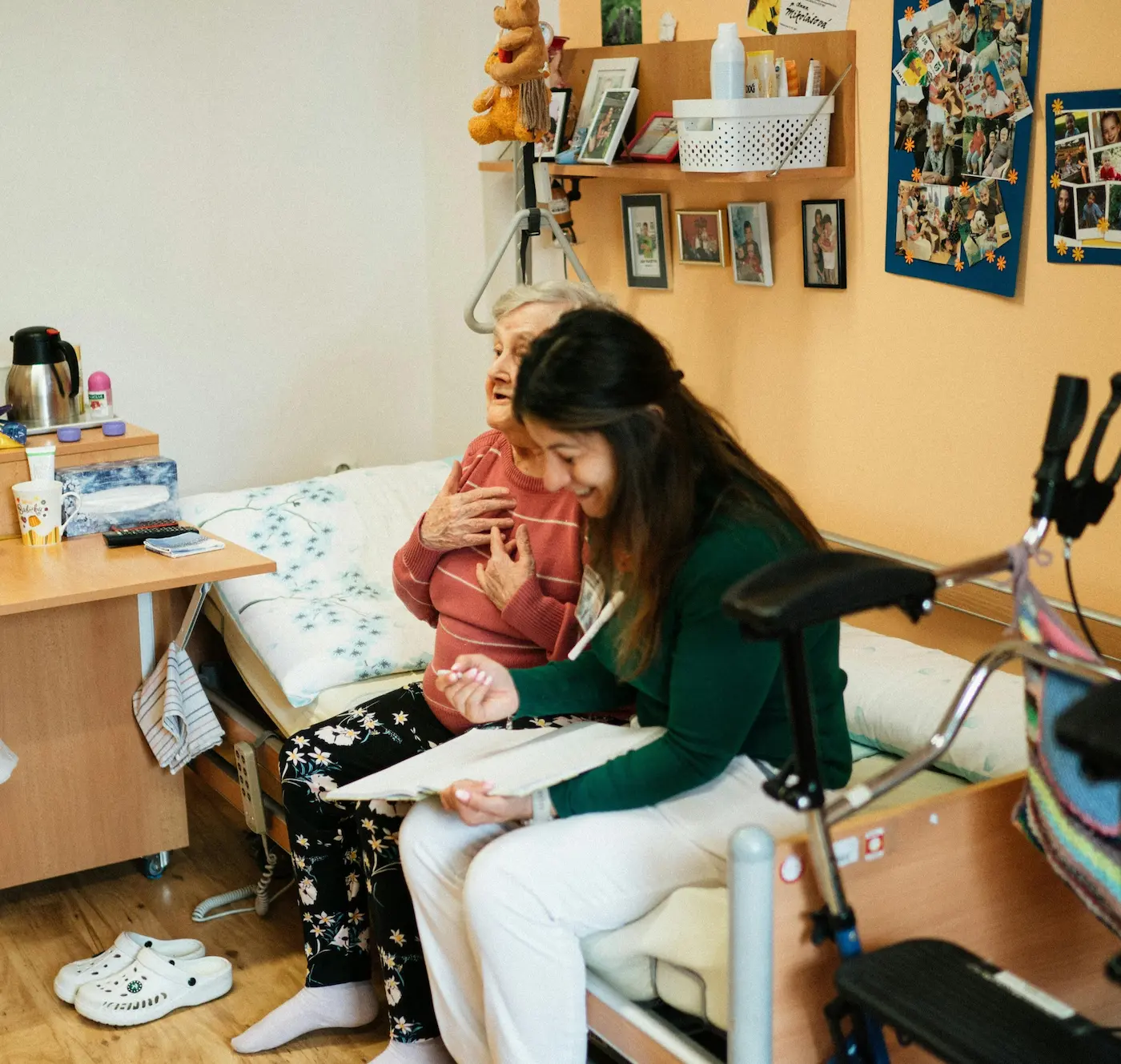 At-home nurse laughing with elderly client while looking through daily to-do list